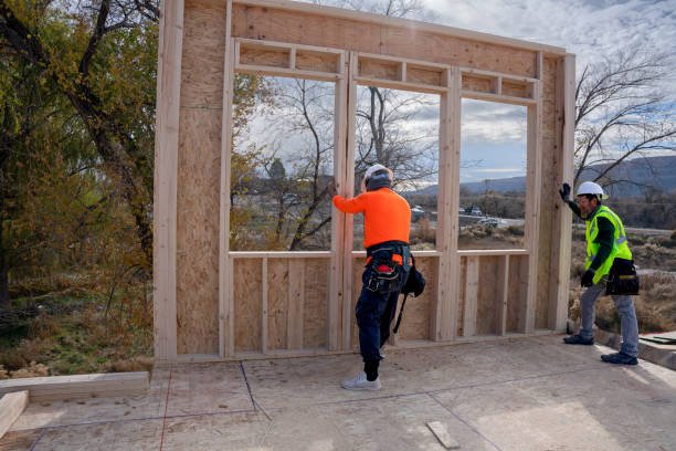 Two men providing handyman services for door and window framing, assembling wood framing on a residential construction site in Huntington Beach.